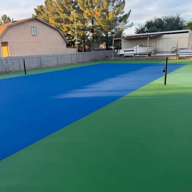 Colorful sports court resurfacing with blue and green markings for basketball and tennis.